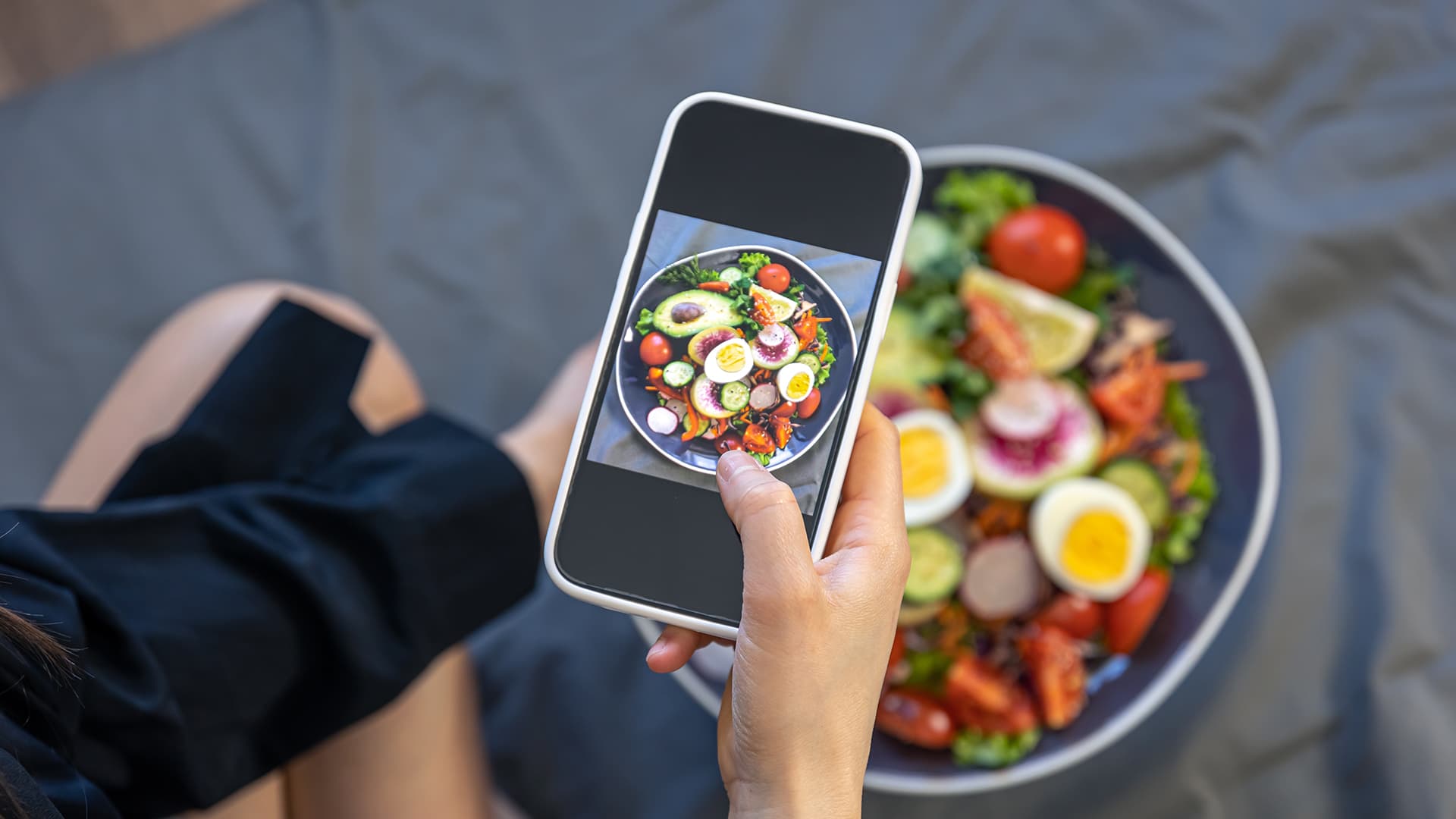Young woman on phone food blogging
